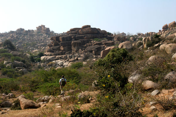 University of Chicago graduate student Andrew Bauer hikes through the hills that conceal the site of Hire Benakal, Karnataka, India. (Samir S. Patel)