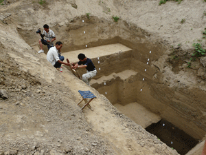 Archaeologist Liu Haiwang climbs out of a pit dug into thousands of years of river sediments