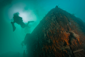 An underwater archaeologist floats beside the <i>Investigator</i> wreck