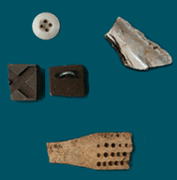 Some of the artifacts unearthed so far include a white porcelain button, a piece of shell cut by prisoners for their craft, a portion of a bone toothbrush, and a hard rubber carved button with a silver loop. Notice that the rubber carving is broken but had probably been prepared for a shell inlay.